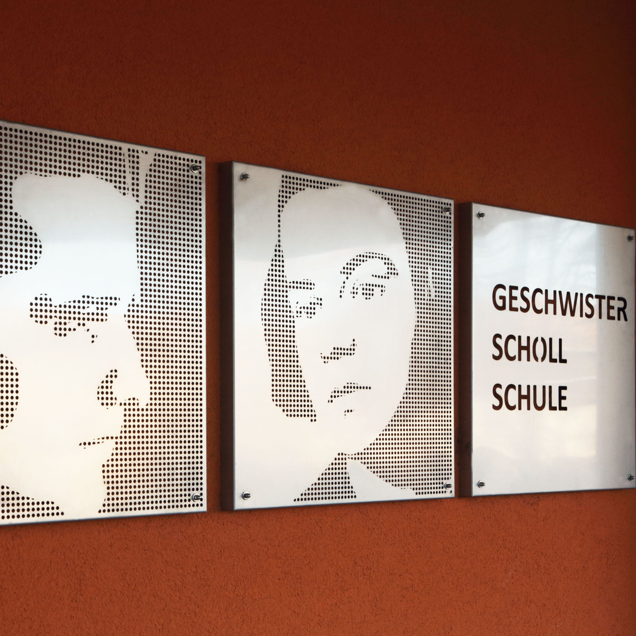Stilisierte Porträts aus Metall von den Geschwister Scholl an einer Schule in Weißensee.
